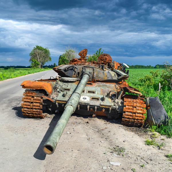 Burnt out tank at the side of a road.