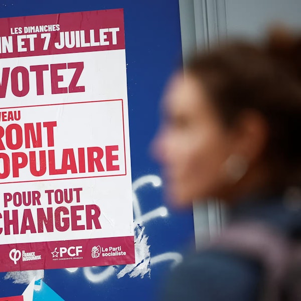 A woman passing a poster for New Popular Front in France