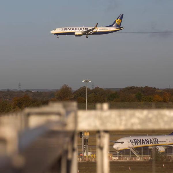 Image showing a Ryanair flight above a forested area with another Ryanair flight in the foreground.