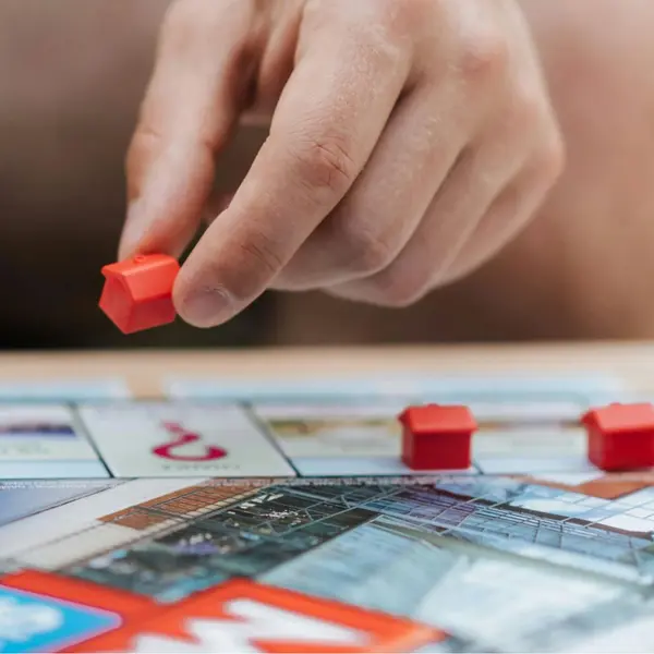 A hand playing the board game Monopoly